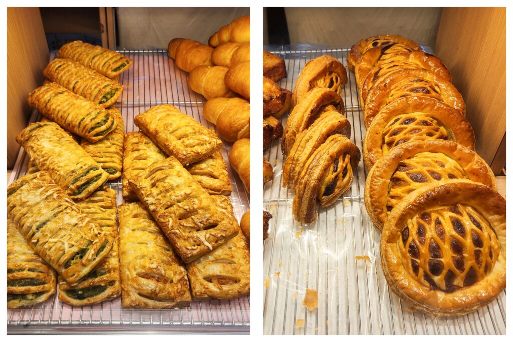 Close-up of assorted puff pastries, including spinach and cheese-filled rectangles and round lattice-topped pies displayed on wire racks