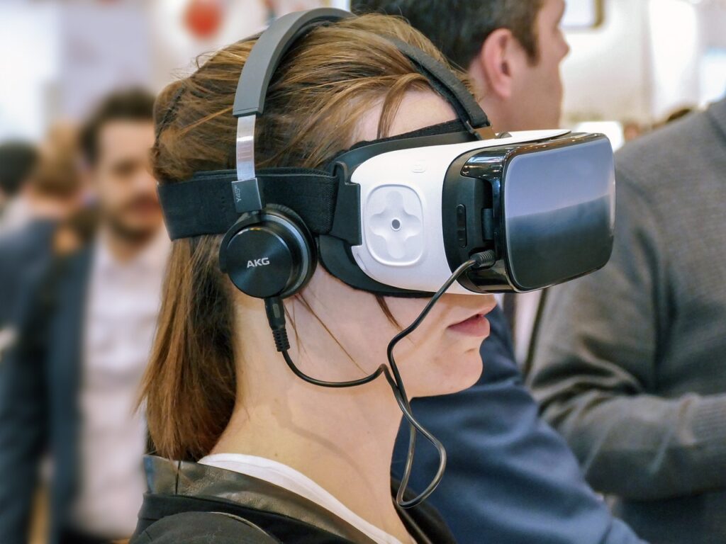 Woman wearing a VR headset and AKG headphones in a crowded event