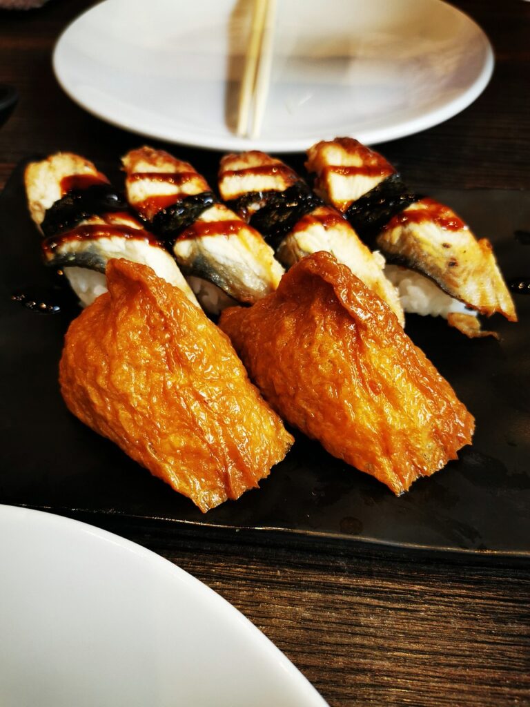 Colorful sashimi and sushi rolls served on a wooden platter with garnish