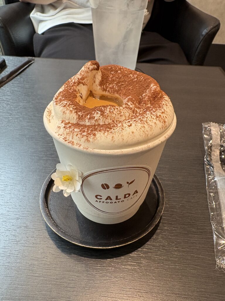 Cute illustrated sticker of a matcha affogato cup from CALDA Affogato Café on a black tabletop.