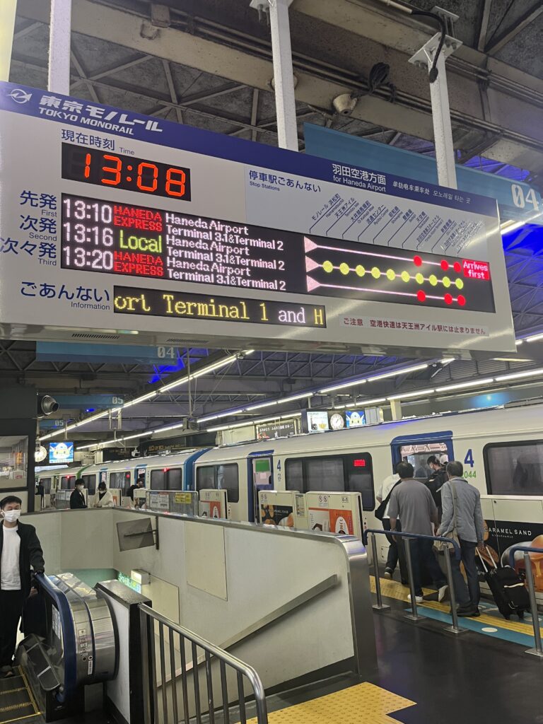 Crowded Tokyo Monorail platform at Hamamatsucho Station during boarding hours.