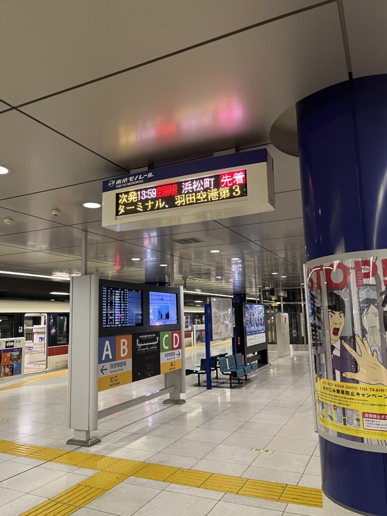 Digital departure board showing Tokyo Monorail train schedule to Haneda Airport.