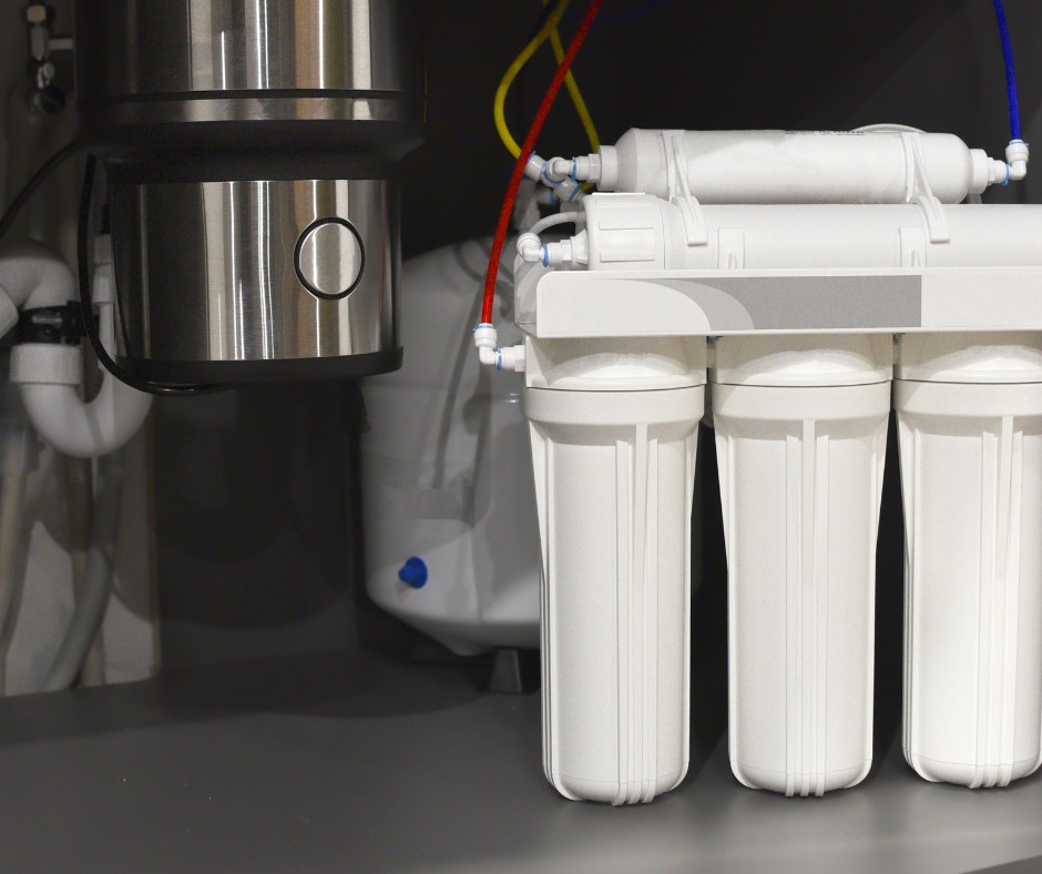 Under-sink reverse osmosis water filtration system with multiple filter cartridges and colored tubes for water lines.