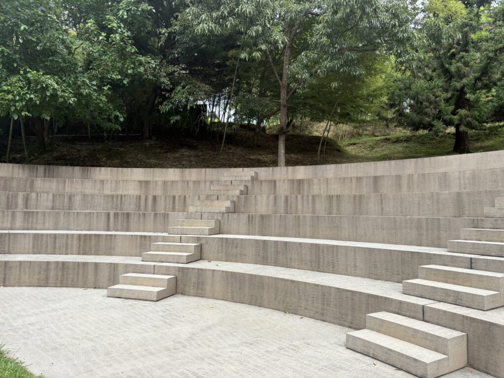 Outdoor stone amphitheater surrounded by trees at Morou Art Forest.