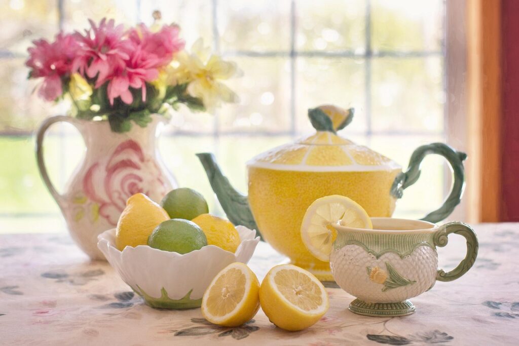 A three-tiered afternoon tea stand with colorful macarons, sweet buns, and a birthday cake.