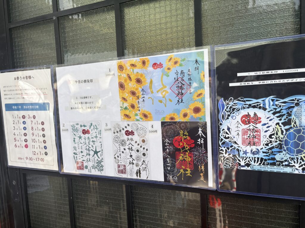 A collection of ornate omamori charms with gold and pink embroidery, neatly arranged on wooden shelves.