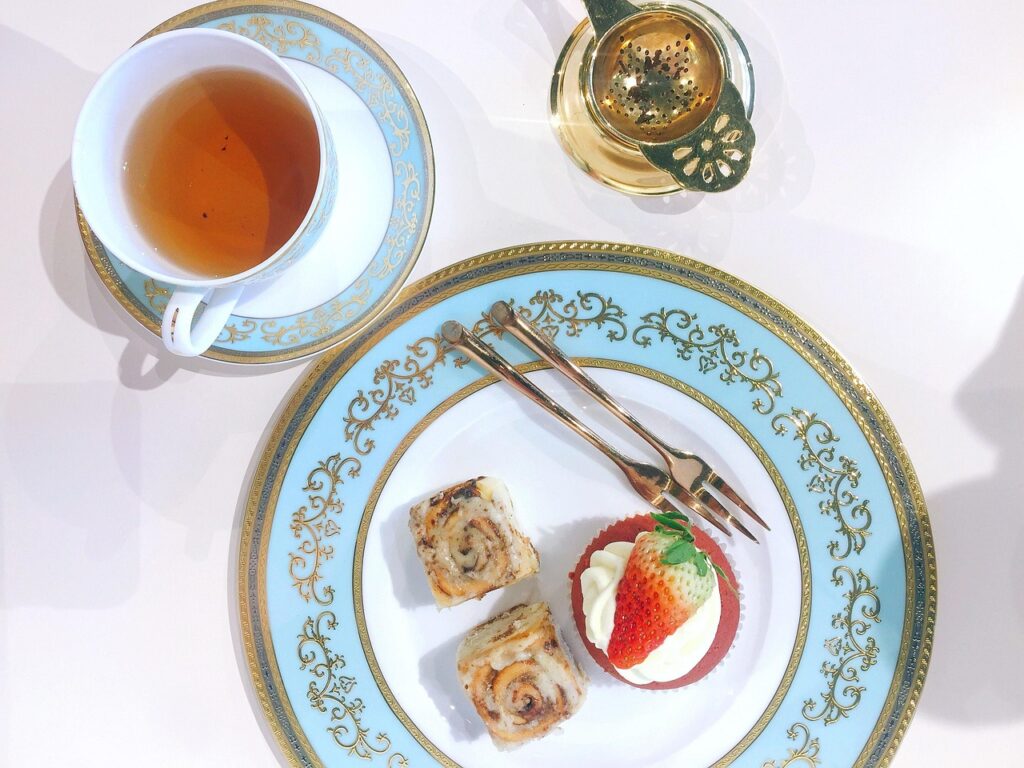 A steaming teacup with traditional Japanese design depicting geishas and a garden.