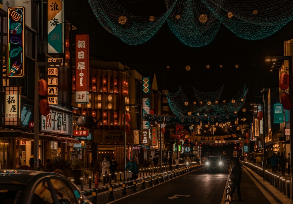 Nighttime view of Tokyo with lingering summer heat, high-rises glowing and streets still warm.