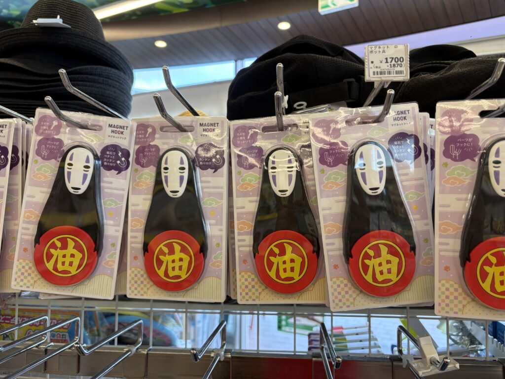 Souvenir shop display of No-Face magnet hooks for sale with price tags.