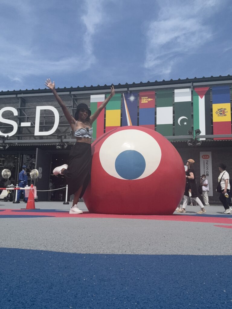 Posing with Expo 2025 mascot sculpture outside pavilions