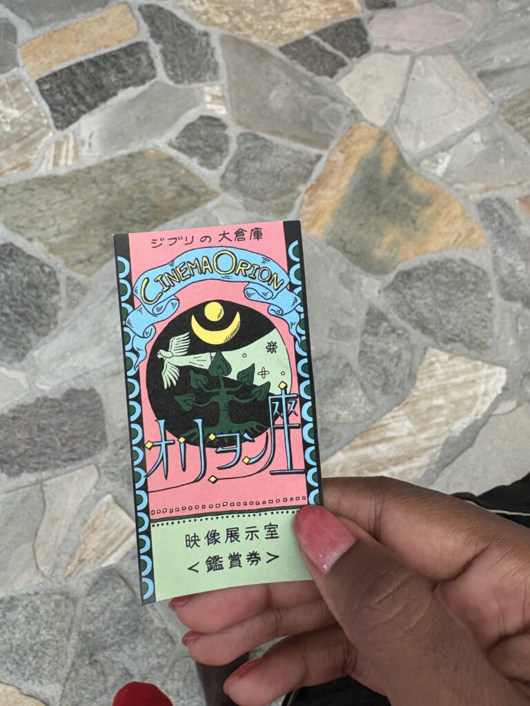 Hand holding a colorful Cinema Orion ticket for the exclusive Ghibli short films.