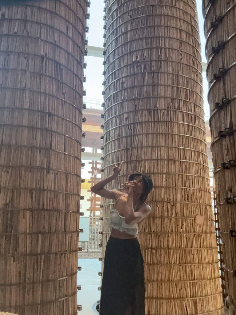 Visitor posing by bamboo pillars inside pavilion at Osaka Expo 2025
