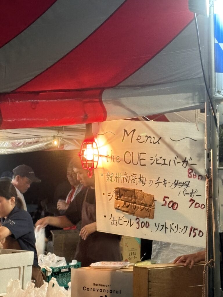 Food stall menu with burgers and drinks at the festival.
