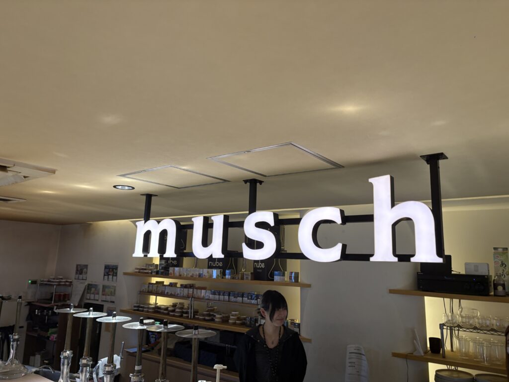 Illuminated Musch sign inside the café.