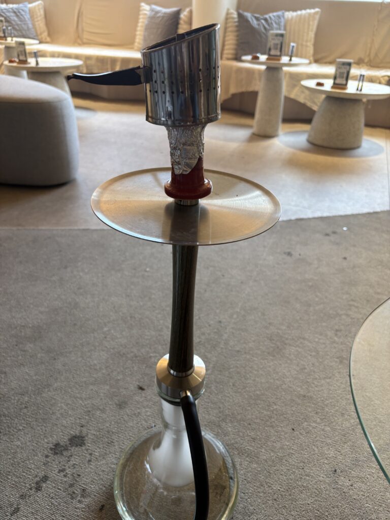 Hookah placed on a glass table inside a minimal café.