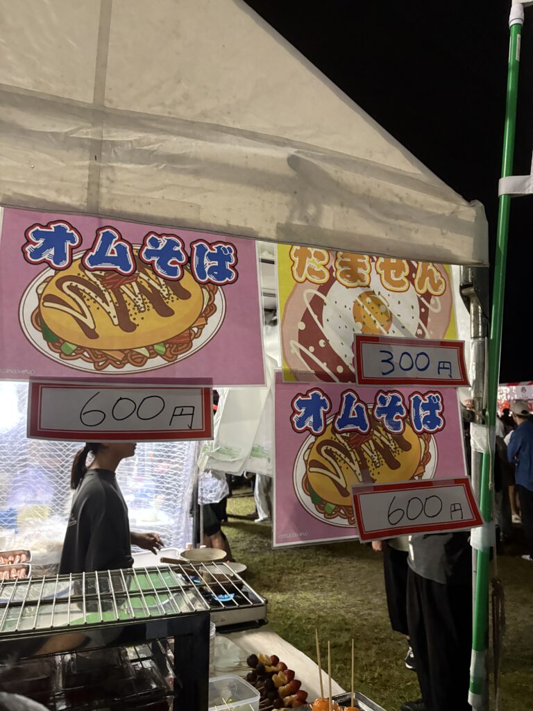 Festival stall selling omusoba and tamasen dishes.
