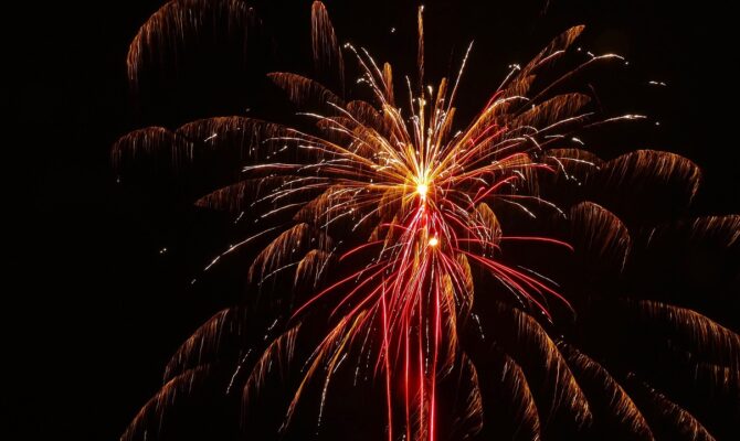 Red and gold fireworks bursting against a dark sky.