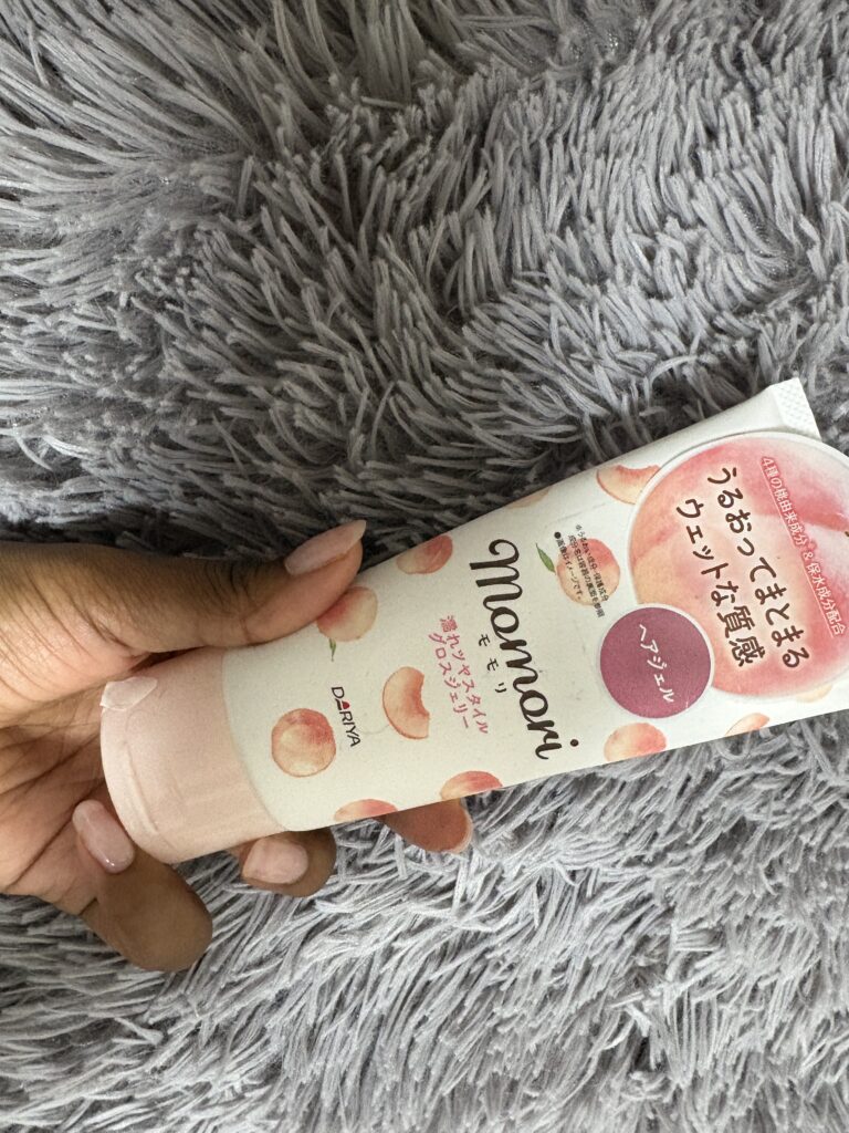Hand holding Momori Natural Hair Wax tube