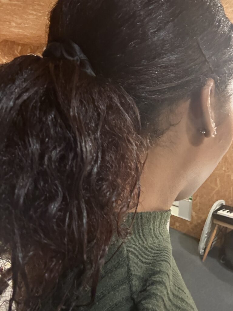 Close-up of low ponytail showing defined curls.