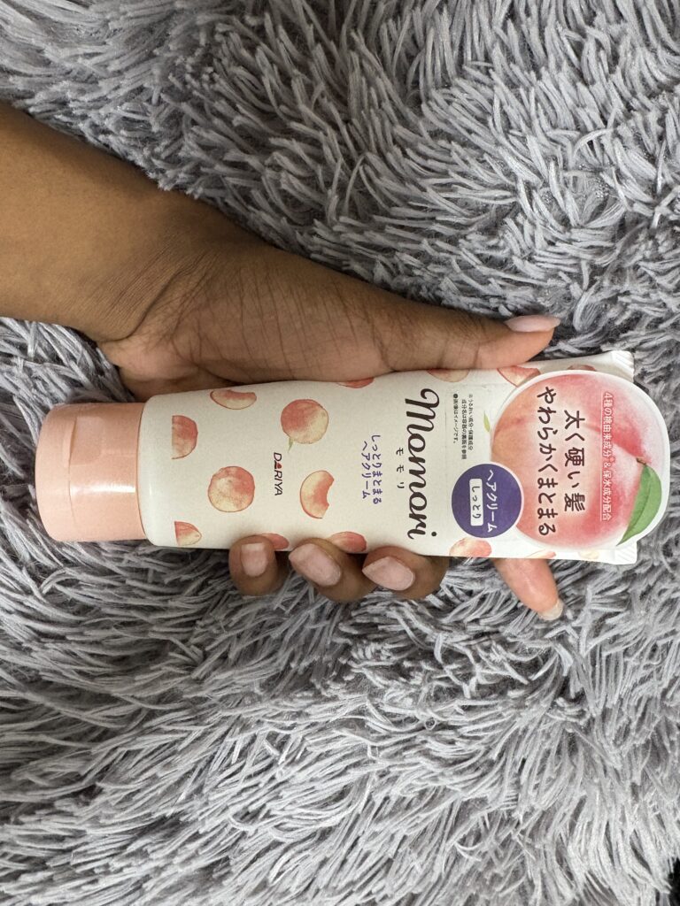 Hand holding Momori Hair Gloss Jelly tube