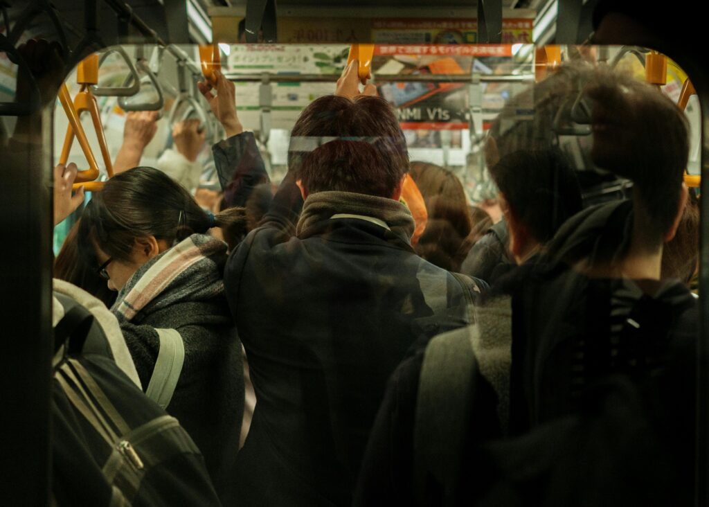 A tightly packed commuter train filled with people standing shoulder to shoulder during rush hour.