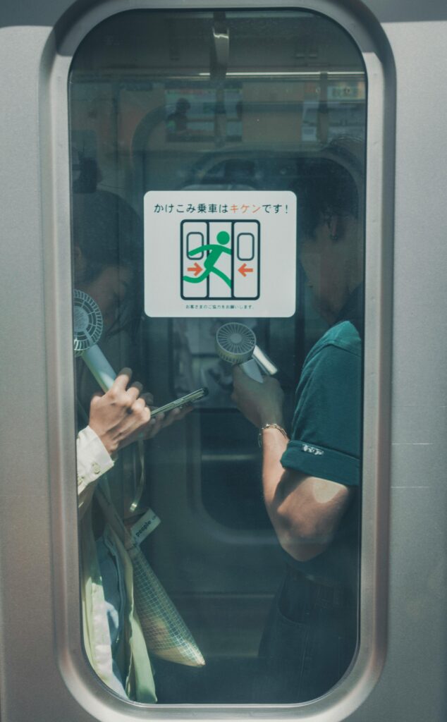 A train door window displaying a safety sign warning passengers that rushing onto the train is dangerous.