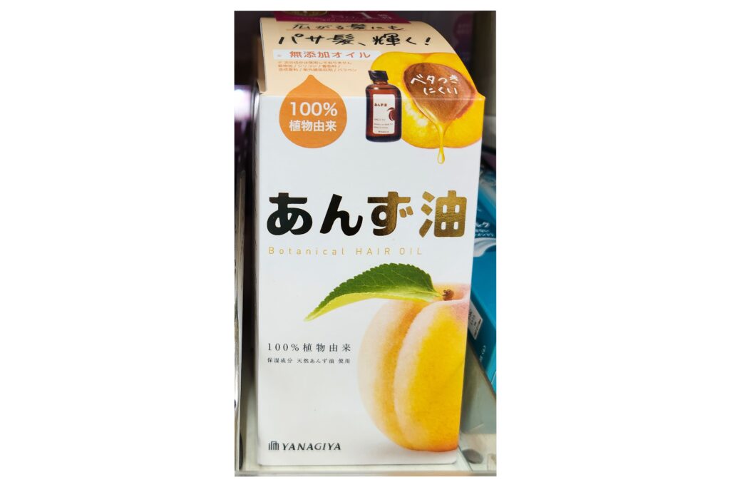 Yanagiya Anzu (Apricot) Botanical Hair Oil box with peach illustration and Japanese text, displayed on a store shelf.