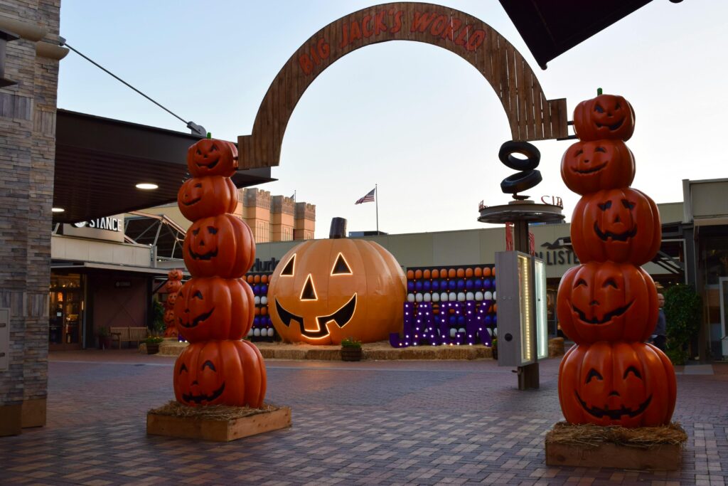 Halloween decorations at Tokyo Dome City featuring large stacked pumpkins and a giant smiling jack-o’-lantern.