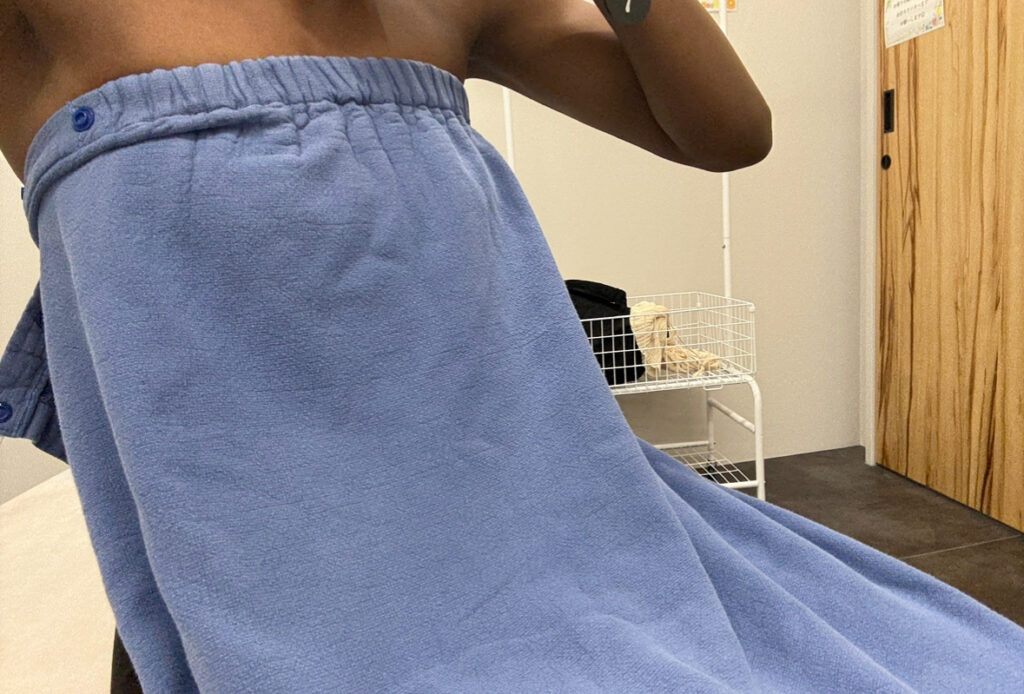 Patient wearing a blue gown before a MiraDry sweat gland removal procedure at a Japanese clinic