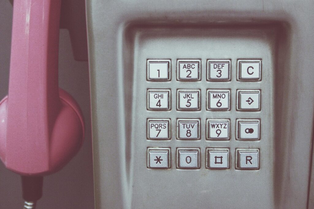 Close-up of a pink vintage telephone keypad, representing reaching out for mental health support and connection.