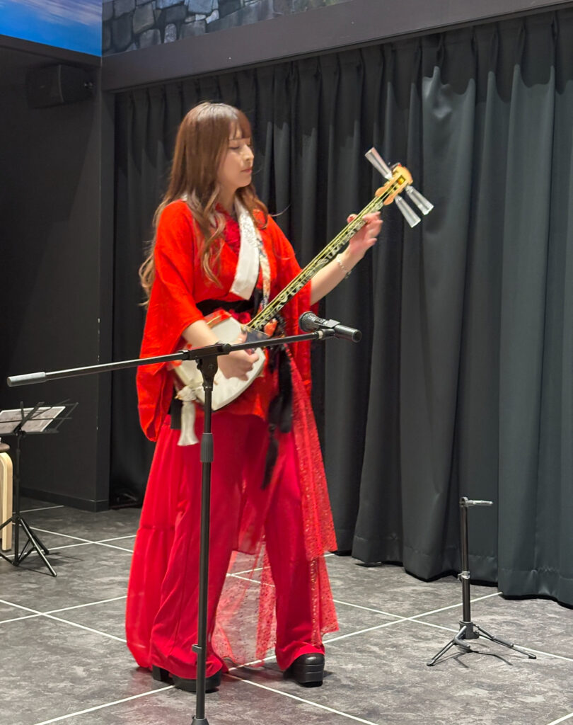A performer playing the shamisen on stage at Michi Cultural Center in Osaka.