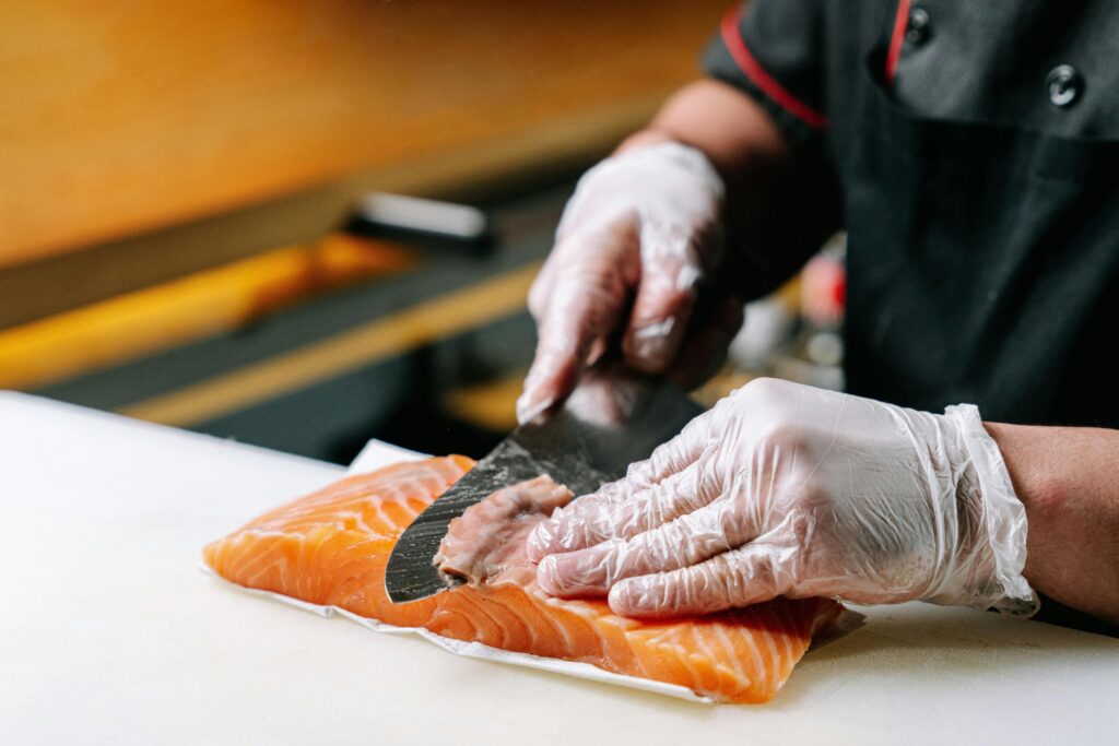 Chef slicing fresh salmon with a sharp Japanese knife