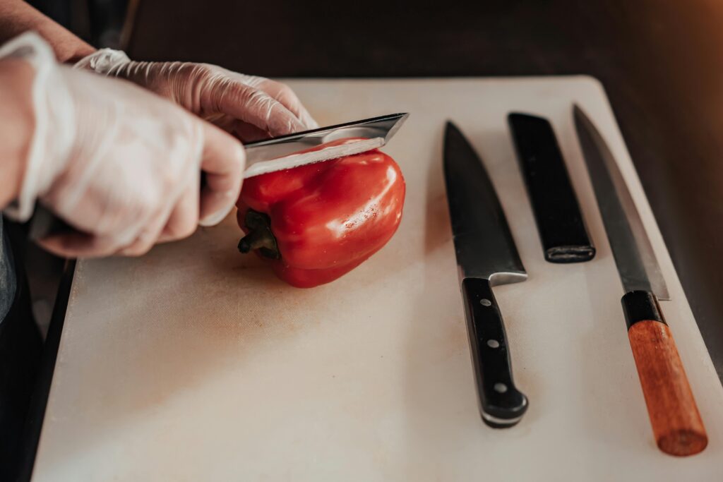 Two Japanese-style kitchen knives beside a plate of cherry tomatoes