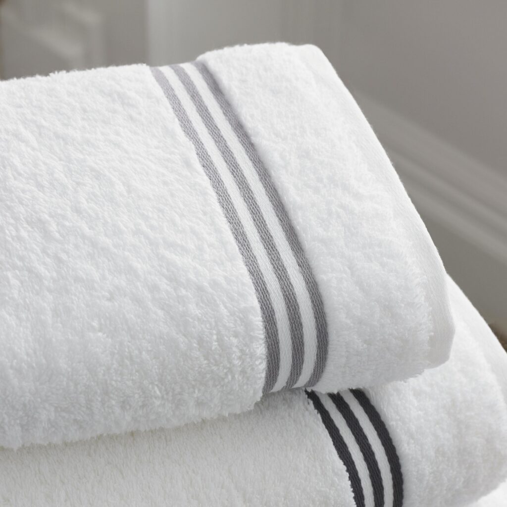 Folded white bath towels with gray stripes