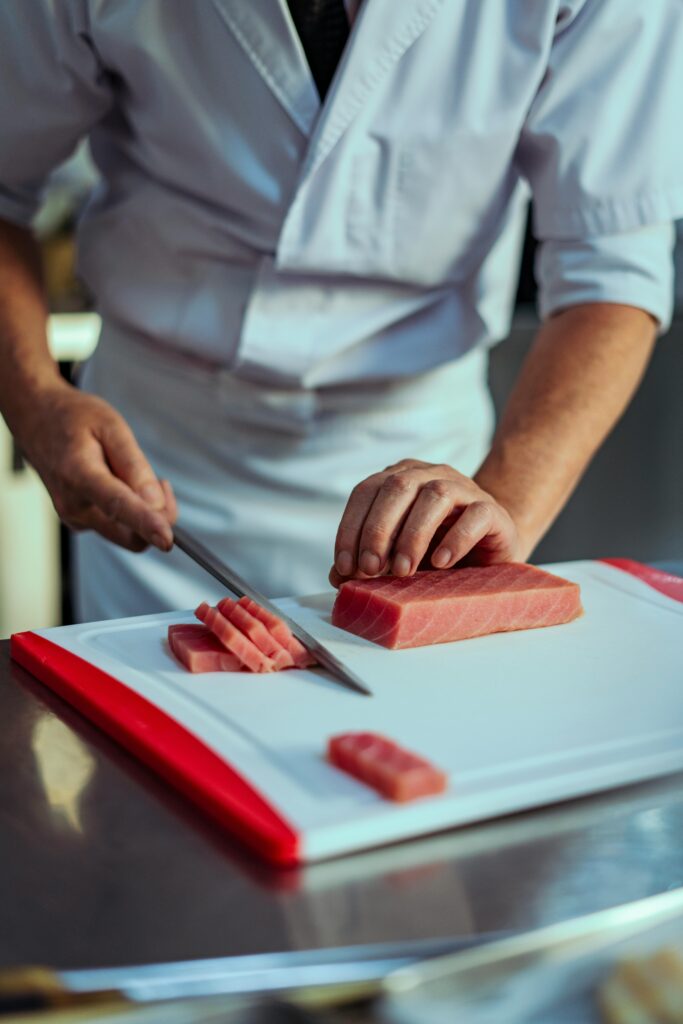 Chef slicing fresh salmon with a sharp Japanese knife