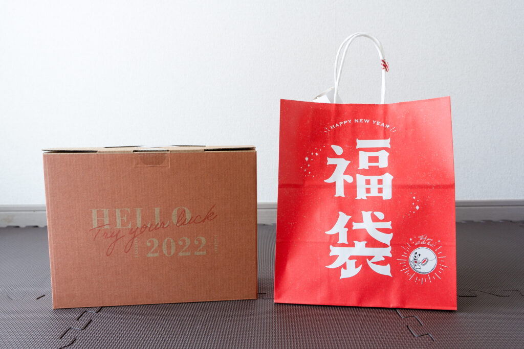 Two New Year lucky bags in Japan, including a brown Heart Bread Antique bakery fukubukuro box and a red traditional fukubukuro shopping bag.