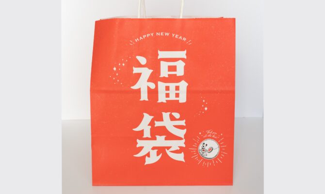 Red Japanese New Year fukubukuro bag with bold white kanji reading “福袋” (lucky bag), placed against a plain background