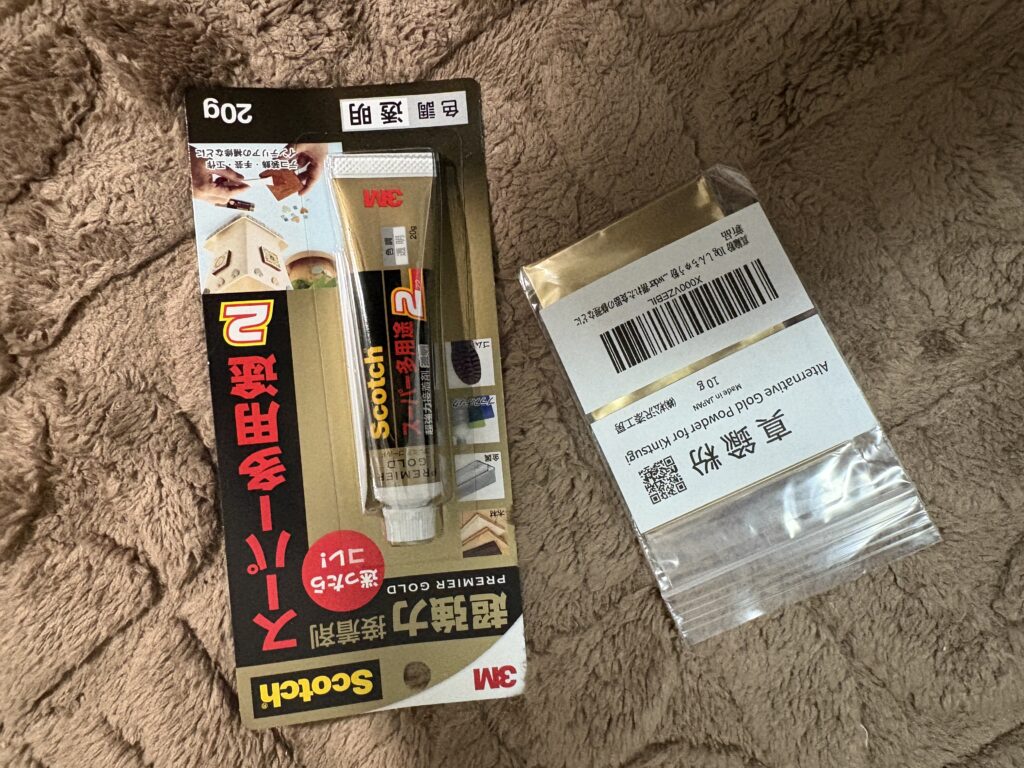 DIY Kintsugi materials including gold-colored adhesive glue and metallic powder prepared for pottery repair.