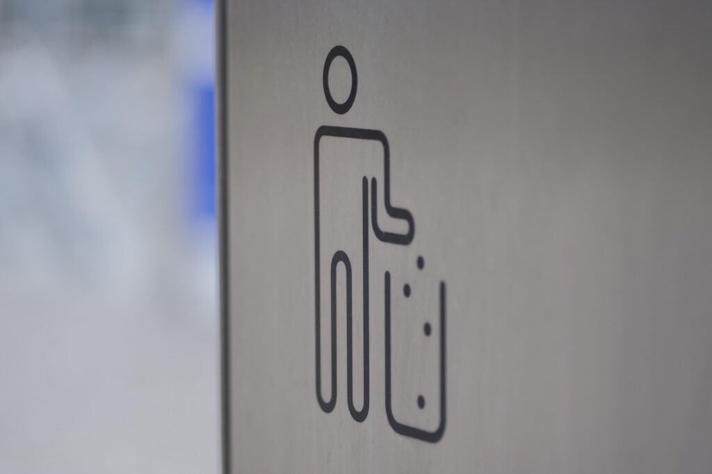 Minimalist icon of a person throwing trash into a bin.