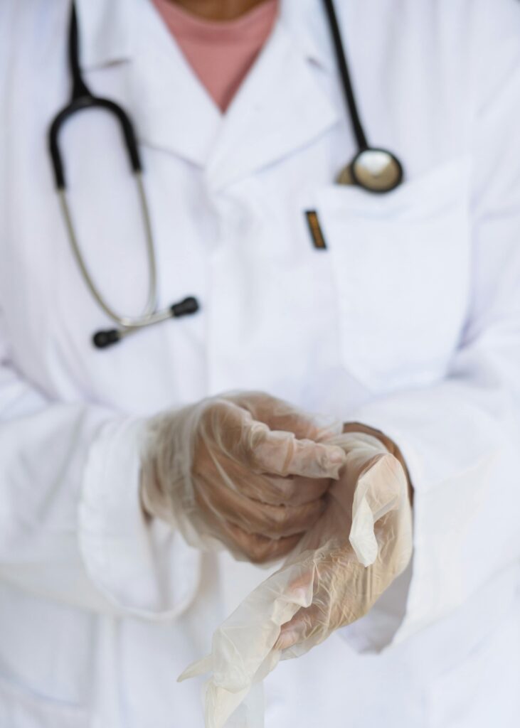 Doctor putting on medical gloves before an examination