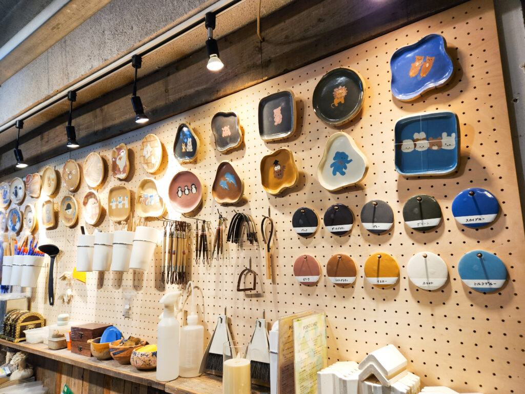 Interior of CREABASE Oshiage studio showing handmade plates, tools, and workshop materials on display