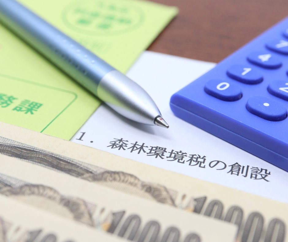 Japanese tax document with a pen, calculator, and 10,000 yen notes on a desk