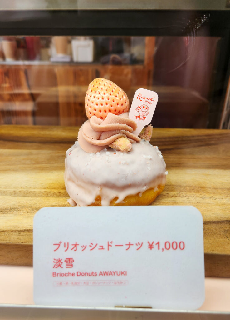 Brioche donut glazed in strawberry icing and topped with rare white Awayuki strawberry at the festival.
