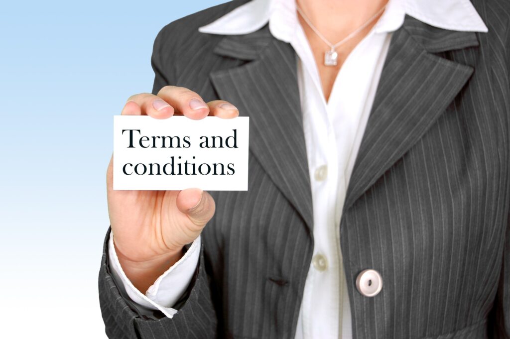 Businesswoman in a suit holding a card that says “Terms and conditions”