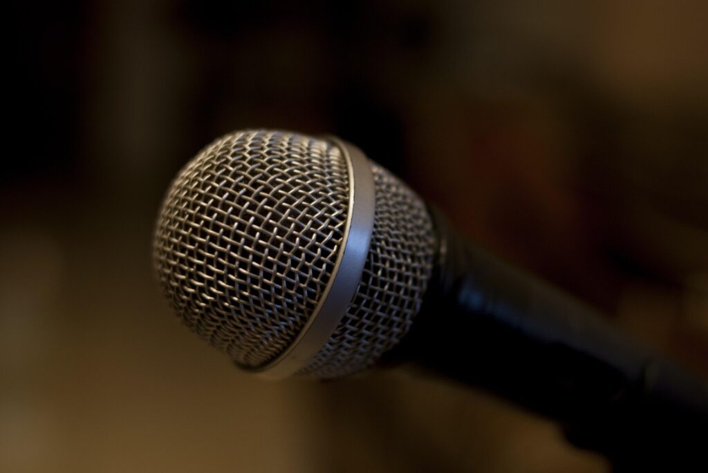 Close-up of a microphone with a blurred dark background.