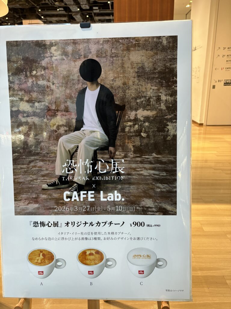 Promotional sign for The Freak Exhibition x CAFE Lab showing special cappuccino designs and event dates in 2026