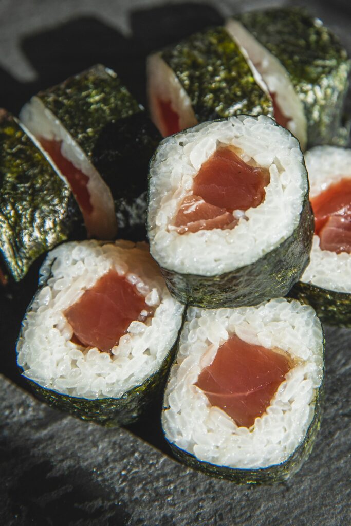Close-up of hand-held sushi wrapped in crisp nori with fresh tuna at a Japanese restaurant