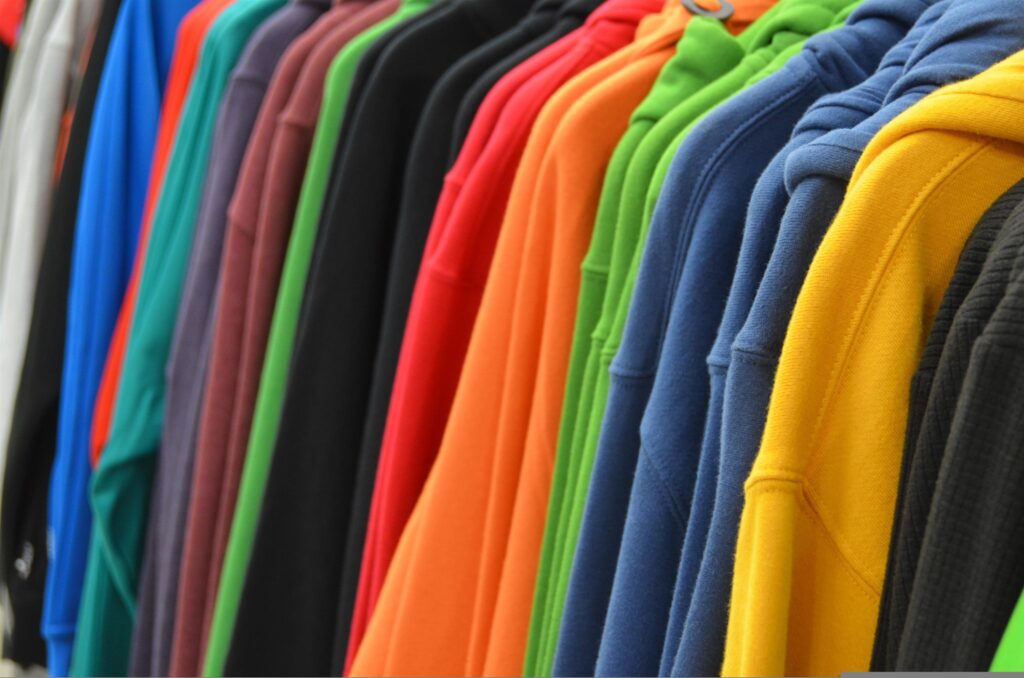Wooden clothing hangers inside a closet illuminated by warm light.