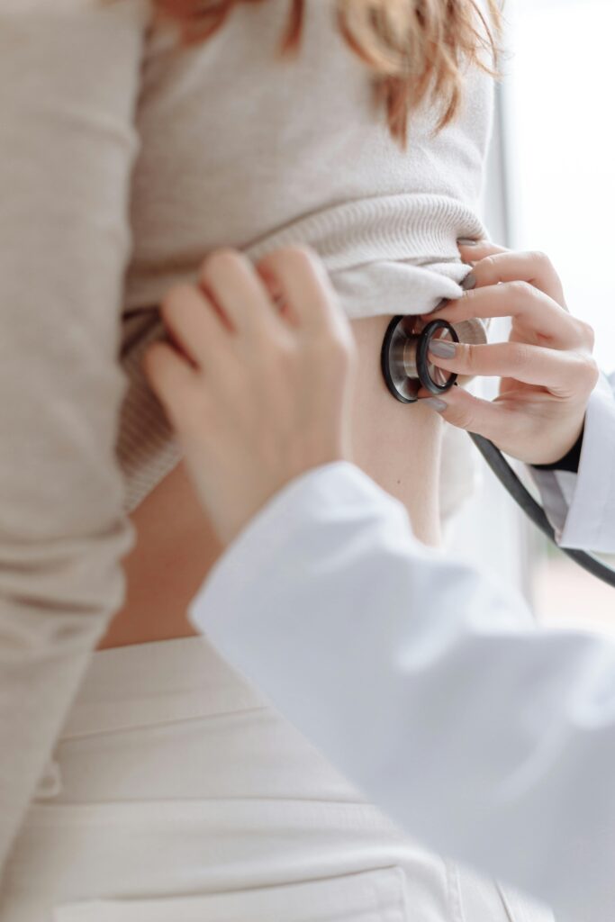 Doctor using a stethoscope to listen to a patient’s chest during a health check