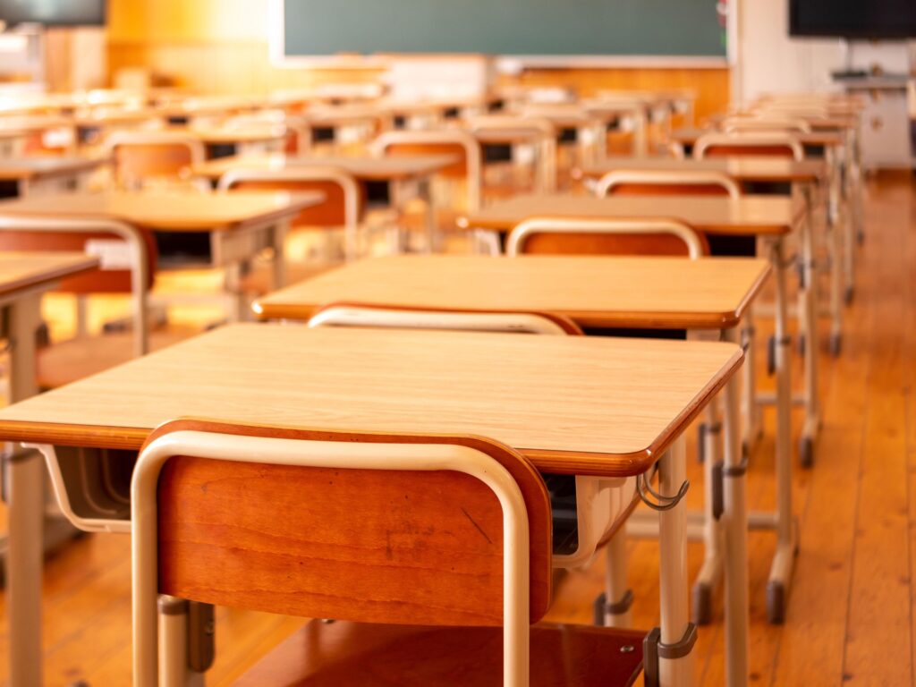 Empty classroom in a Japanese school with rows of desks and a chalkboard.